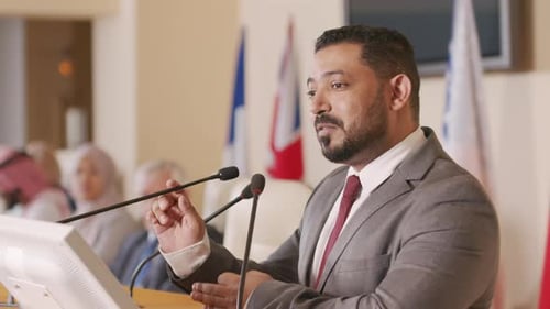 Man in Suit Giving Speech at Podium