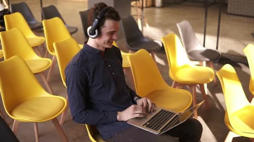 Young Adult Using Laptop in Modern Office Space