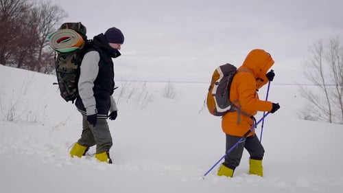 Hikers Trekking Through Snowy Winter Landscape