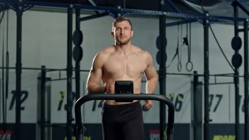 Muscular Man Jogging on Treadmill in Gym