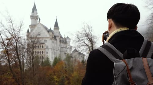 Young Adult Photographing Neuschwanstein Castle in Germany
