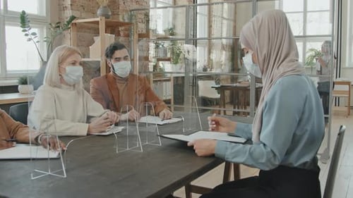 Business Meeting with Masks in a Modern Office
