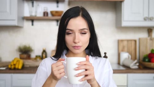 Woman Holding a Mug in Bright Kitchen