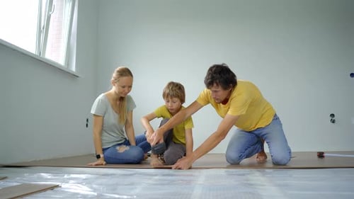 Family Installing New Wood Floor in Home