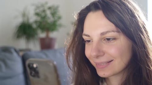 Smiling Woman Using Smartphone Indoors During Daytime