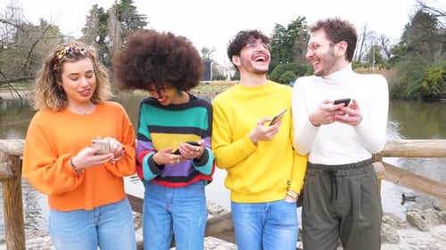 Four Friends Using Smartphones in the Park