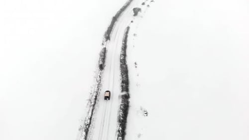 Vehicle Driving Snowy Rural Road Aerial Winter Scene