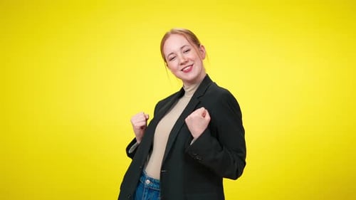 Young Woman Dancing Against Bright Yellow Background