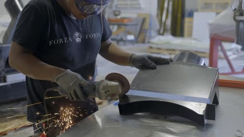 Worker cutting a part of oven in workshop
