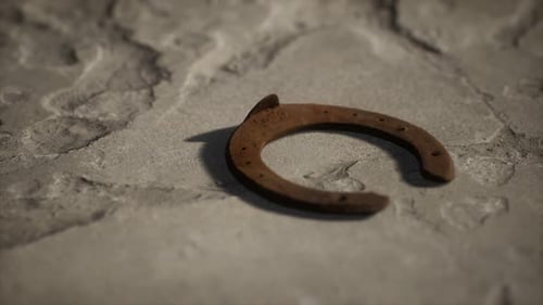 Rotating Old Rusty Horseshoe on Textured Stone Background