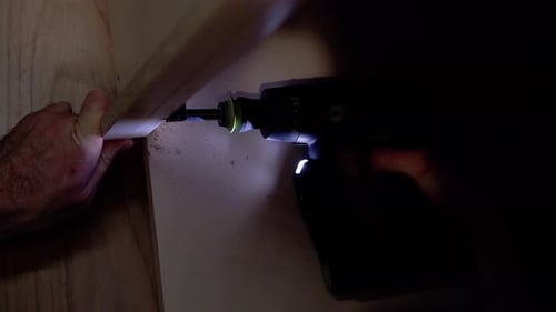 Screwing the Screw Into the Table Surface with a Screwdriver 5 Screwdriver Highlights the Place of