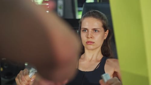 Woman Exercising Chest Press with Trainer in Gym
