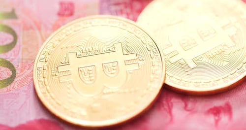 Close up Bitcoin Coins on Chinese Yuan Banknote