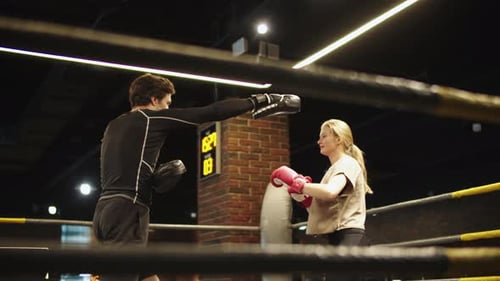 Beautiful Fit Girl Training in Sport Club. Male Boxer Giving Instructions at Gym