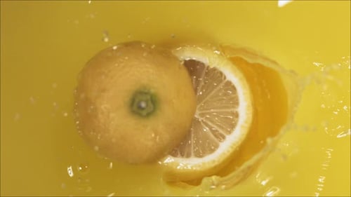 Lemon Slice Splashing into Vibrant Orange Juice