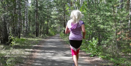 Woman Running on a Forest Trail