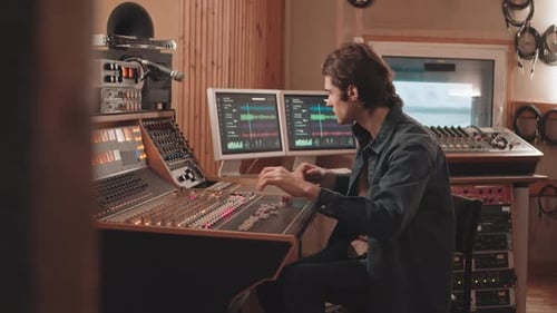 Man Using Mixing Board while Recording Music at Studio