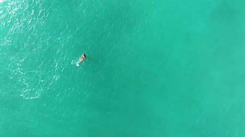 A man swims in the sea aerial view 4K