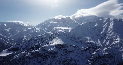 Vuele sobre pueblos nevados de montañas y tierras altas en el valle de Alamut en Irán, día soleado con mucho