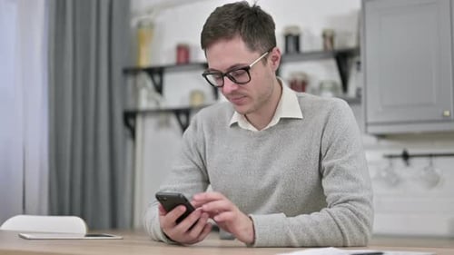 Young Man Using Smartphone, Browsing Internet