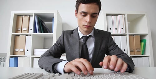 Young Adult Typing on Computer Keyboard in Office