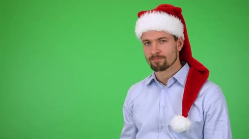 A Man in a Christmas Hat Shows a Thumb Down To the Camera and Shakes His Head - Green Screen Studio