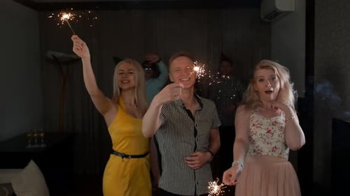 Young Adults Celebrate with Sparklers at Party