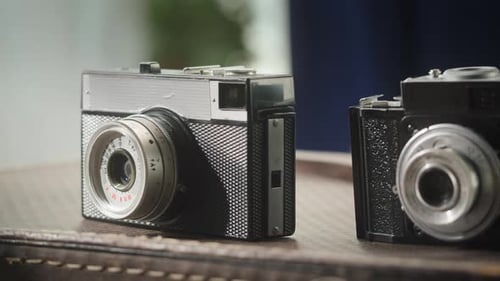 Vintage Cameras on Dark Brown Patterned Surface