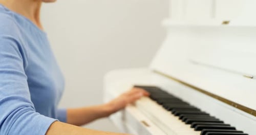 Woman Playing Piano in Bright Room