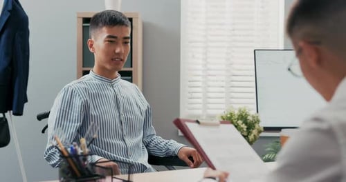 Zwei Männer treffen sich morgens in einem Firmenbüro zu einem Vorstellungsgespräch Behinderter Junge kommt im Rollstuhl an