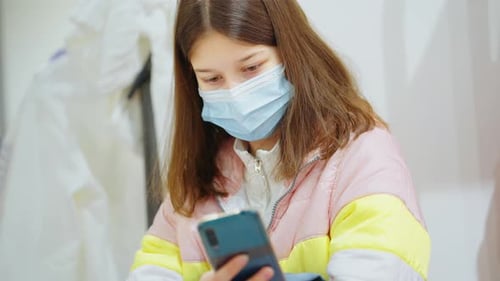 Teen with Mask Using Cellphone Close Up