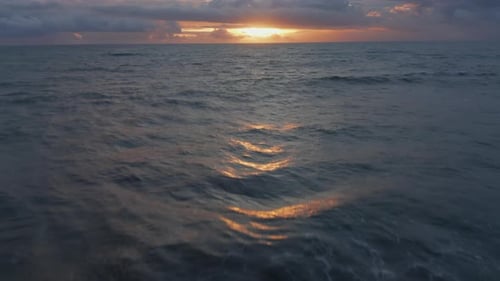Aerial Dolly Shot of Blue Sea Waves During Golden Sunset