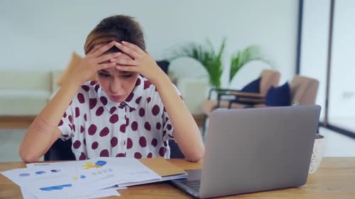 Une jeune gestionnaire de femme caucasienne bouleversée regarde des documents financiers au bureau