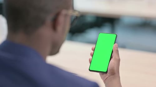 Rear View of Young Businessman Using Smartphone with Chroma Screen