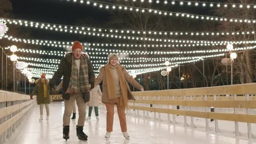 Families Ice Skating Together at a Winter Night Rink
