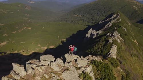 Aerial View of Hiker Couple of Tourists with Backpack on Top of a Mountain