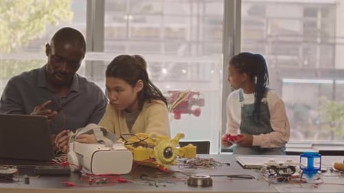 Teacher of Electronics with Pupils Making Experiments in School Lab