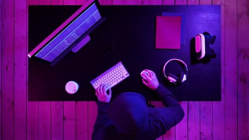 Person Typing at Computer With VR Headset