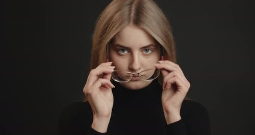 Woman Puts on Stylish Glasses in Close Up