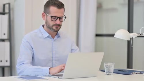 Man working at desk massages sore neck