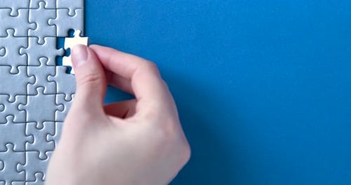 Completing White Puzzle on Blue Background