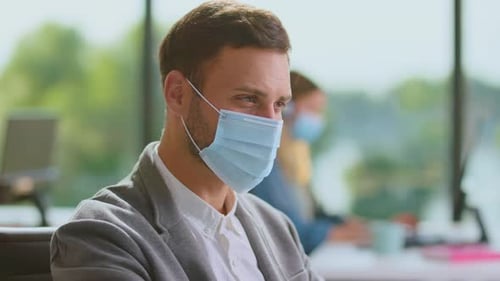 Man in Mask Works in Modern Office