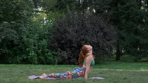 Woman Doing Yoga in City Park on Mat