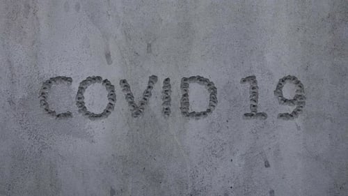 COVID-19 Text Reveal on Gritty Concrete Surface