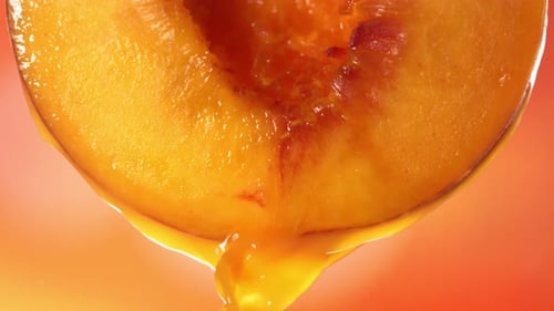Slow Motion Macro Shot of Flowing Peach Juice From Half Peach
