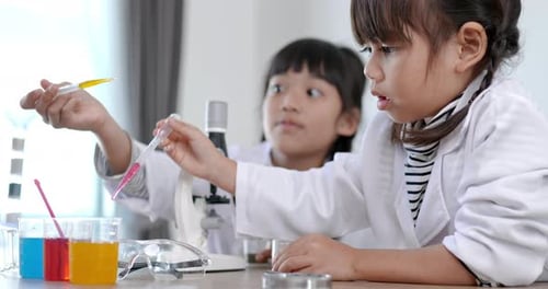Young Girls Doing Science Experiment with Liquids