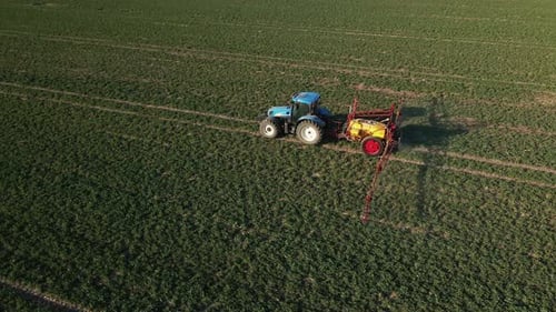 Tractor Spray Fertilizer on Agricultural Field Aerial View
