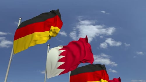 Waving Flags of Bahrain and Germany with a Blue Sky Background