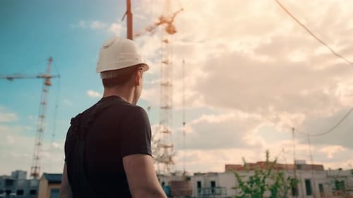 Construction Worker Surveys the Building Site at Daytime
