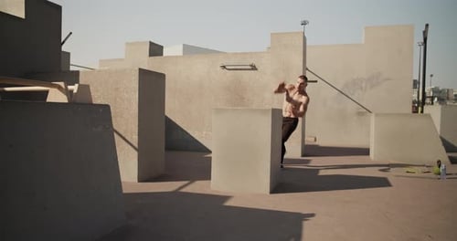 Muscular Man Doing Parkour in Urban Environment